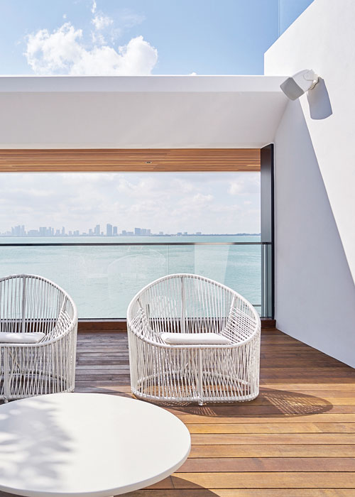 An oceanside patio with a wall-mounted outdoor speaker. 