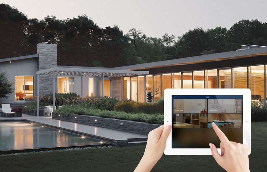 A woman is controlling her smart home system through Savant’s app on her tablet.